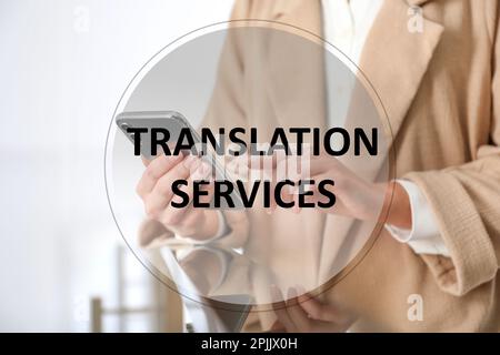 Übersetzungsdienstleistungen. Junge Frau, die drinnen ein modernes Smartphone benutzt, Nahaufnahme Stockfoto