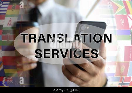 Übersetzungsdienstleistungen. Ein Mann, der sein Smartphone im Haus hält, Nahaufnahme Stockfoto