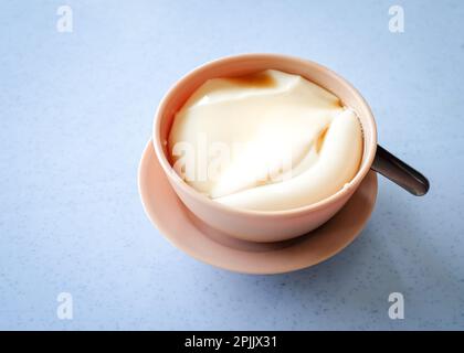 Tau foo fah (Sojabohnenpudding) in einer Schüssel auf einem Tisch. Speicherplatz kopieren. Stockfoto