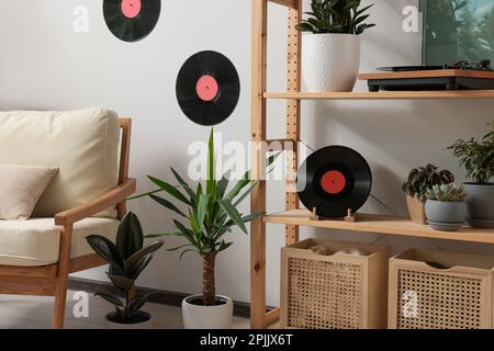Wohnzimmereinrichtung mit stilvollem Plattenspieler auf Holzregalen und Schallplatten Stockfoto