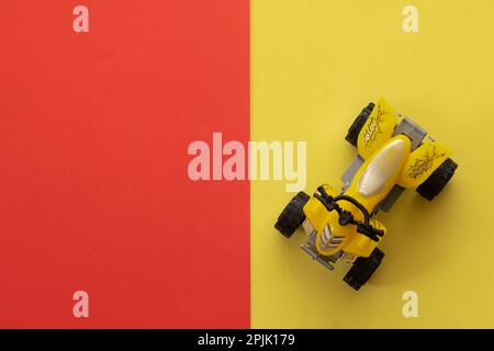 Miniatur-ATV in Gelb auf gelbem und rotem Hintergrund Stockfoto