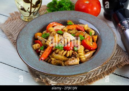 Pasta mit gebratenem Hähnchen, Pilzen, Pfeffer und Kürbis Stockfoto