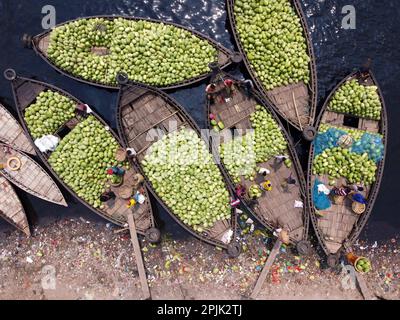 3. April 2023, Dhaka, Dhaka, Bangladesch: Dutzende von Booten, die Tausende von leuchtend grünen Wassermelonen transportieren, legen an einem geschäftigen Markt in der Nähe des Buriganga in Dhaka, Bangladesch an. Händler bringen die Früchte - bis zu 2 00.000 pro Tag - aus ländlichen landwirtschaftlichen Flussgebieten in die Hauptstadt Dhaka, um sie landesweit zu verteilen. Die Arbeiter, die nur 3,50 GBP pro Tag verdienen, verbringen den ganzen Tag damit, schwere Körbe mit Wassermelonen zu entladen. Jede Wassermelone wird für weniger als 1 GBP verkauft. Wassermelone ist in tropischen Ländern wie Bangladesch sehr gefragt und erleichtert jedem die Wärme. Voll von h Stockfoto