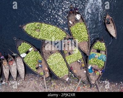 3. April 2023, Dhaka, Dhaka, Bangladesch: Dutzende von Booten, die Tausende von leuchtend grünen Wassermelonen transportieren, legen an einem geschäftigen Markt in der Nähe des Buriganga in Dhaka, Bangladesch an. Händler bringen die Früchte - bis zu 2 00.000 pro Tag - aus ländlichen landwirtschaftlichen Flussgebieten in die Hauptstadt Dhaka, um sie landesweit zu verteilen. Die Arbeiter, die nur 3,50 GBP pro Tag verdienen, verbringen den ganzen Tag damit, schwere Körbe mit Wassermelonen zu entladen. Jede Wassermelone wird für weniger als 1 GBP verkauft. Wassermelone ist in tropischen Ländern wie Bangladesch sehr gefragt und erleichtert jedem die Wärme. Voll von h Stockfoto