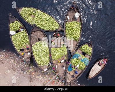 3. April 2023, Dhaka, Dhaka, Bangladesch: Dutzende von Booten, die Tausende von leuchtend grünen Wassermelonen transportieren, legen an einem geschäftigen Markt in der Nähe des Buriganga in Dhaka, Bangladesch an. Händler bringen die Früchte - bis zu 2 00.000 pro Tag - aus ländlichen landwirtschaftlichen Flussgebieten in die Hauptstadt Dhaka, um sie landesweit zu verteilen. Die Arbeiter, die nur 3,50 GBP pro Tag verdienen, verbringen den ganzen Tag damit, schwere Körbe mit Wassermelonen zu entladen. Jede Wassermelone wird für weniger als 1 GBP verkauft. Wassermelone ist in tropischen Ländern wie Bangladesch sehr gefragt und erleichtert jedem die Wärme. Voll von h Stockfoto