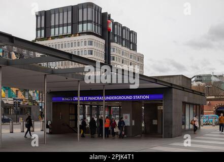 Die Menschen betreten und verlassen die King's Cross St. Pancras U-Bahnstation an einem bewölkten Tag. Dahinter befindet sich das Gebäude des Standard Hotels. Stockfoto