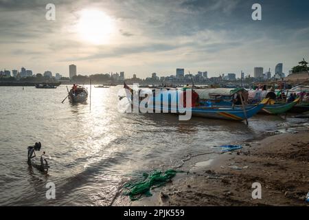 Phnom Penh, Kambodscha-Dezember 24. 2022: Kleine, schmale Boote, teilweise gegen die Elemente bedeckt und von Khmer-Familien als Unterkünfte genutzt, sitzen auf weniger Stockfoto