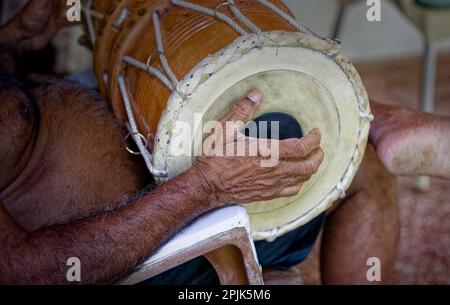 Ein erwachsener Mann, der dolak-Trommel spielt, ein traditionelles Schlaginstrument, ein Spieler, ein Schlagzeuger Stockfoto