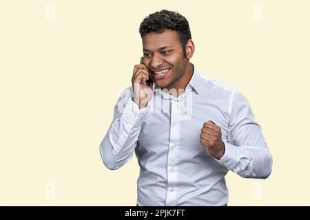Porträt eines jungen indischen Geschäftsmanns, der telefoniert. Isoliert auf weißem Hintergrund. Stockfoto