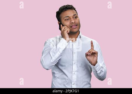 Porträt eines jungen indischen Geschäftsmanns, der telefoniert. Isoliert auf weißem Hintergrund. Stockfoto