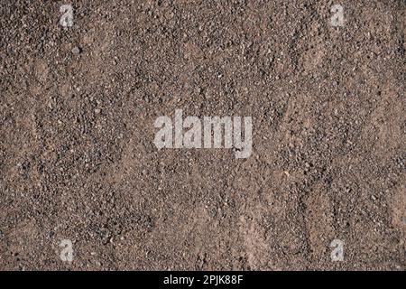 Dunkelbrauner Kieshintergrund. Gängige Stadttexturen Stockfoto