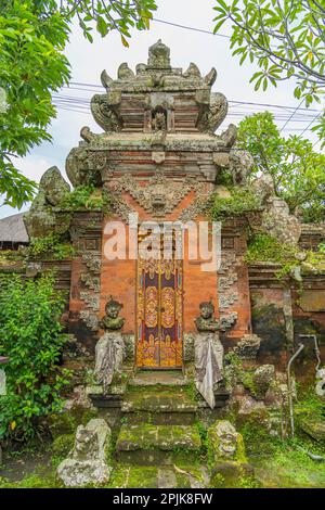 Holztore von einem Haus. Traditionelle balinesische Haustore mit Naturstein und geschnitztem Holz in Ubud Stockfoto