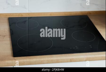 Neuer Elektroherd mit Induktionsherd in der Küche. Induktionskeramik-Kochfeld Stockfoto