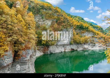 Wunderschöne Herbstlandschaft des Corlo-Sees in Italien, umgeben von Felsen. Stockfoto