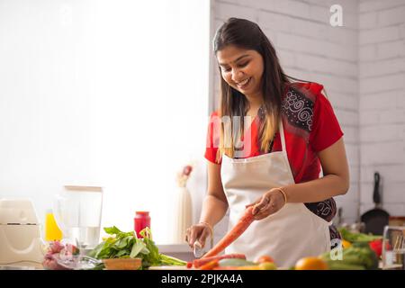 Lächelnde Frau Hacken Gemüse in der Küche Stockfoto