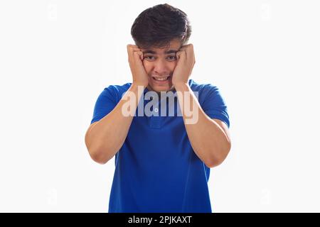 Porträt eines frustrierten jungen Mannes vor weißem Hintergrund Stockfoto