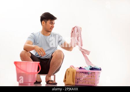 Porträt eines jungen Mannes, der seine Wäsche von Hand wäscht Stockfoto