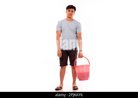 Junger Mann mit Eimer in der Hand vor weißem Hintergrund Stockfoto