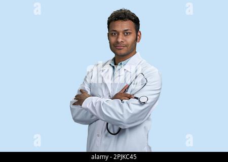Lächelnder männlicher indischer Arzt, der medizinische Kittel und Stethoskop trägt. Selbstbewusster Krankenhausarzt oder Chirurg. Stockfoto