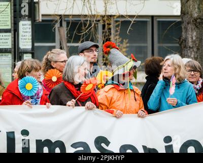 Straßburg, Frankreich - 29. März 2023: Eine Menge hochrangiger Umweltaktivisten und Demonstranten vor dem Europäischen Gerichtshof für Menschenrechte in Straßburg, die sich gegen Luftverschmutzung, Klimawandel und globale Erwärmung einsetzen. Plakate mit Slogans prangern die Untätigkeit der Regierung an, während grüne Flaggen für einen gesünderen Planeten winken. Stockfoto