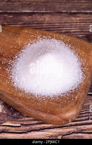 Granulatzucker. Weißer raffinierter Zucker auf Holzhintergrund. Stockfoto