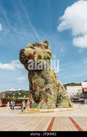 Bilbao, Spanien - September 2022: Hündchen, die von Jeff Koons entworfene blumige Hundeskulptur, vor dem Guggenheim-Museum in Bilbao, Spanien, in sonniger Umgebung Stockfoto
