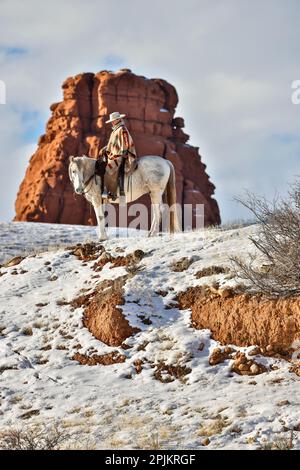 USA, Wyoming. Versteck dich auf der Horse Ranch, Rangler auf dem Pferderücken im Schnee. (HERR, PR) Stockfoto