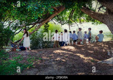 Sevilla, Spanien; 2. April 2023: Gruppe von Kindern, die während der Heiligen Woche am Ufer des Flusses Guadalquivir spielen. Palmsonntag. Stockfoto