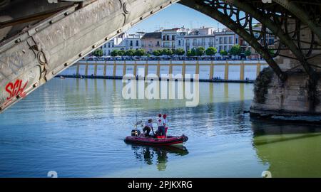 Sevilla, Spanien; 2. April 2023: Spanisches Rotkreuz-Boot auf dem Fluss Guadalquivir während der Heiligen Woche. Palmsonntag. Stockfoto