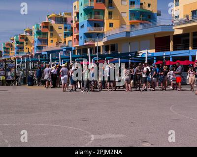 Eine Reihe von Touristen in der Marina von Albufeira warten auf eine der Touristenboote entlang der Algarve Küste Portugal EU Stockfoto