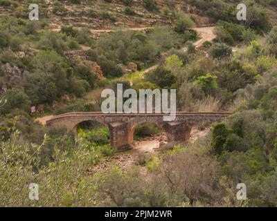 Blick auf die römische Brücke Ponte de Paderne über das trockene Flussbett des Quarteira Paderne Algarve Portugal der Fluss EU ist seit zwei Jahren trocken Stockfoto