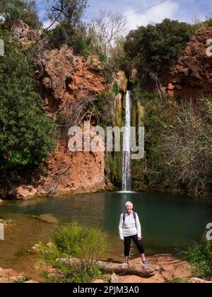 Ältere weibliche Touristen, die Queda do Vigario Falls besuchen Alte Algarve Portugal EU Herbst 24m über Klippen in ein tiefes Becken mit Feigenbäumen Ältere Frau Stockfoto