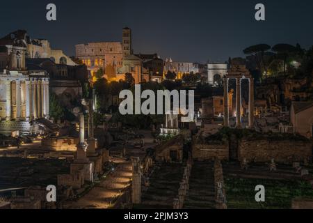 Nachtsicht auf das Forum Romanum und das Kolosseum mit malerischer Beleuchtung, Rom, Italien Stockfoto