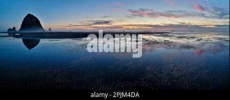 USA, Oregon. Cannon Beach und Panoramablick auf Hystack bei Sonnenuntergang und Ebbe. Stockfoto
