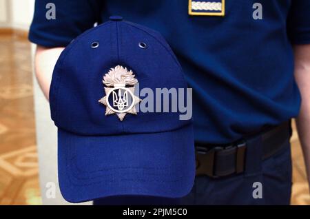 Die Hand eines ukrainischen Polizisten mit einer blauen Mütze und einem Wappen Tryzub. Demonstration neuer Polizeiausrüstung, Ausrüstung und Uniformen. 7. Oktober 2018. Kiew, Stockfoto