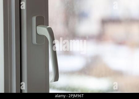 An einem bewölkten Tag im Winter geschlossenes weißes PVC-Kunststofffenster. Foto in hoher Qualität. Horizontal. Hintergrund. Stockfoto