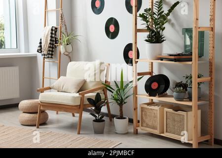 Wohnzimmereinrichtung mit stilvollem Plattenspieler auf Holzregalen und Schallplatten Stockfoto