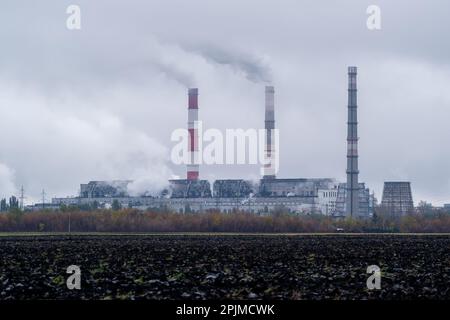 Zeitraffer von Dämpfen schädlicher toxischer Substanzen in Form von dickem weißem Rauch, der aus den Rohren einer chemischen Anlage in die Umwelt abgegeben wird Stockfoto