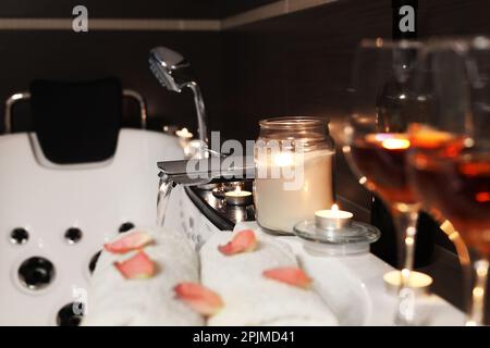 Kerzen und Handtücher auf der Badewanne im Bad, Platz für Text. Romantische Atmosphäre Stockfoto