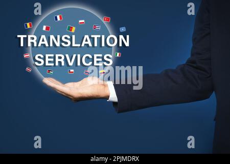 Übersetzungsdienstleistungen. Virtuelles Symbol für die Demonstration mit Text und Flaggen auf blauem Hintergrund, Nahaufnahme Stockfoto