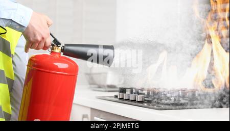 Ein Mann, der in der Küche ein brennendes Kochfeld mit Feuerlöscher ausstellt, schließt. Bannerdesign Stockfoto