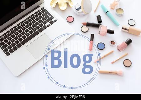 Arbeitsplatz des Bloggers mit Laptop und Make-up-Produkten auf weißem Hintergrund, flach verlegt Stockfoto