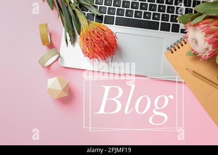 Arbeitsplatz des Bloggers mit Laptop und Blumen auf pinkfarbenem Hintergrund, flach liegend Stockfoto
