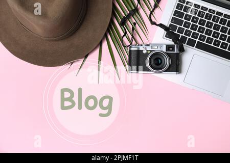 Arbeitsplatz des Bloggers mit Laptop und Kamera auf pinkfarbenem Hintergrund, flach liegend Stockfoto