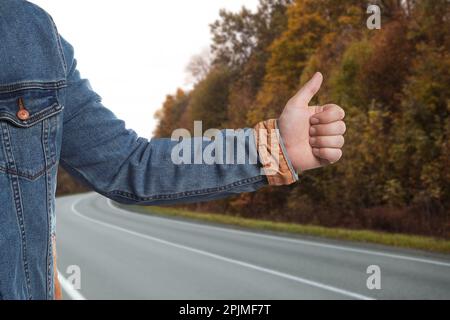 Ein Mann, der auf der Straße Auto fängt, Nahaufnahme. Anhalter-Tour Stockfoto