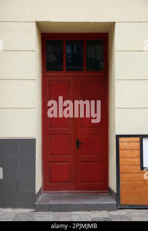 Eingang des Hauses mit wunderschöner roter Tür und Heckfenster Stockfoto