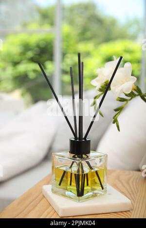 Reed-Diffusor auf einem hölzernen Nachttisch im Schlafzimmer Stockfoto