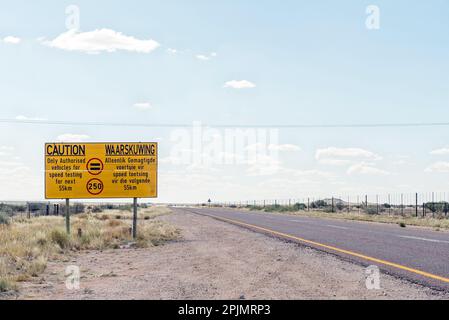 Ein Warnschild für 250 km Geschwindigkeitsbegrenzung für Testfahrzeuge auf der R360-Straße zwischen Askham und Upington in der Provinz Nordkap von Südafrika Stockfoto