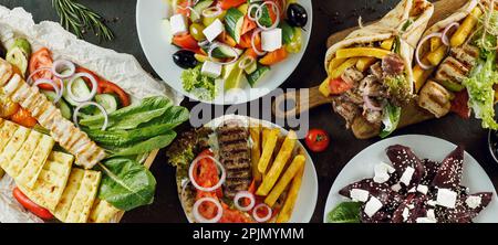 Griechisches Essen auf dunklem Hintergrund, langes horizontales Banner. Gyros, griechischer Salat, Souvlaki – Auswahl an griechischen Gerichten Stockfoto