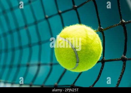 Ein Tennisball traf ein schwarzes Netz auf einem Tennisplatz Stockfoto